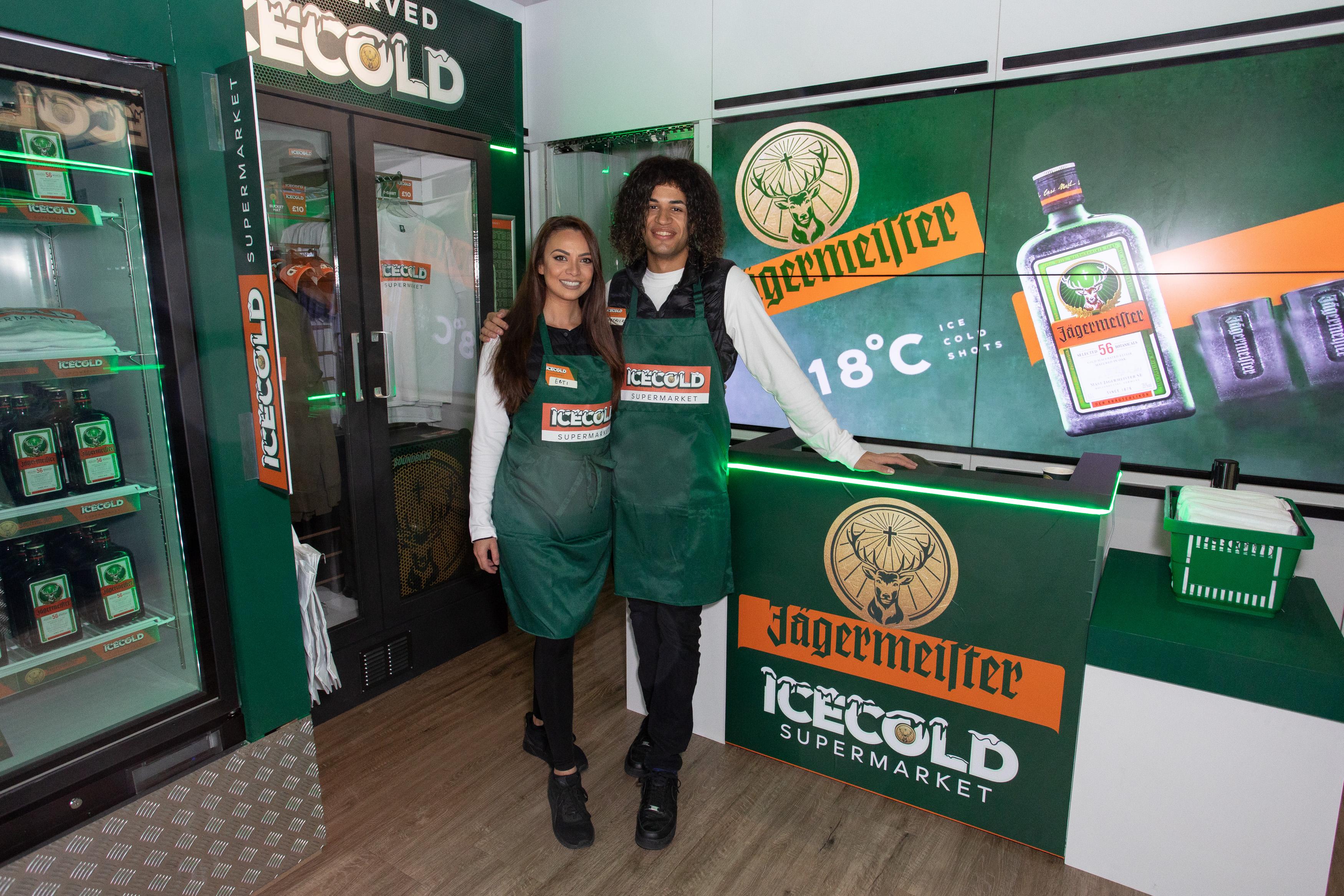 Sook Space Jagermeister pop up with two Jagermeister staff posing smiling in front of cash desk
