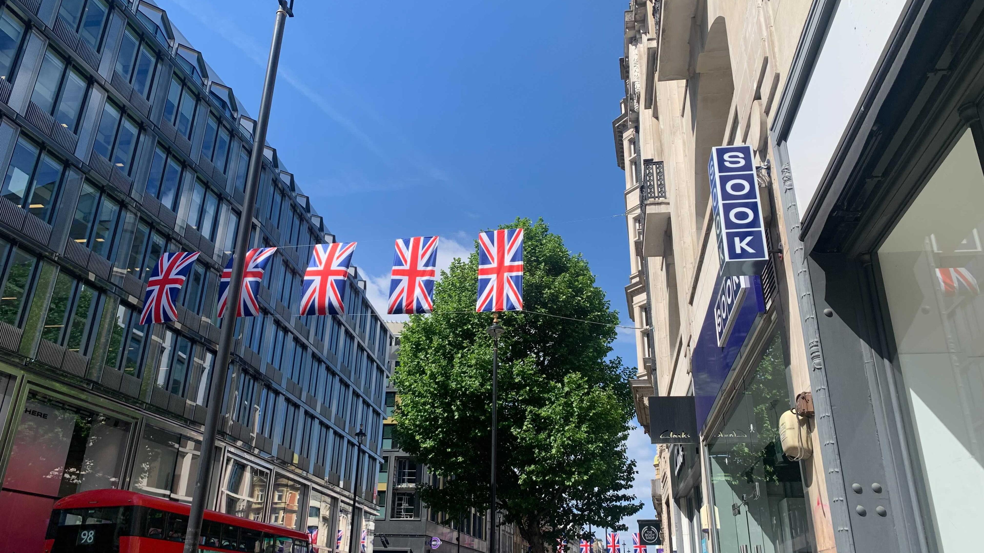 Blue sky above Sook store in Oxford Street with british flag bunting hanging across the street