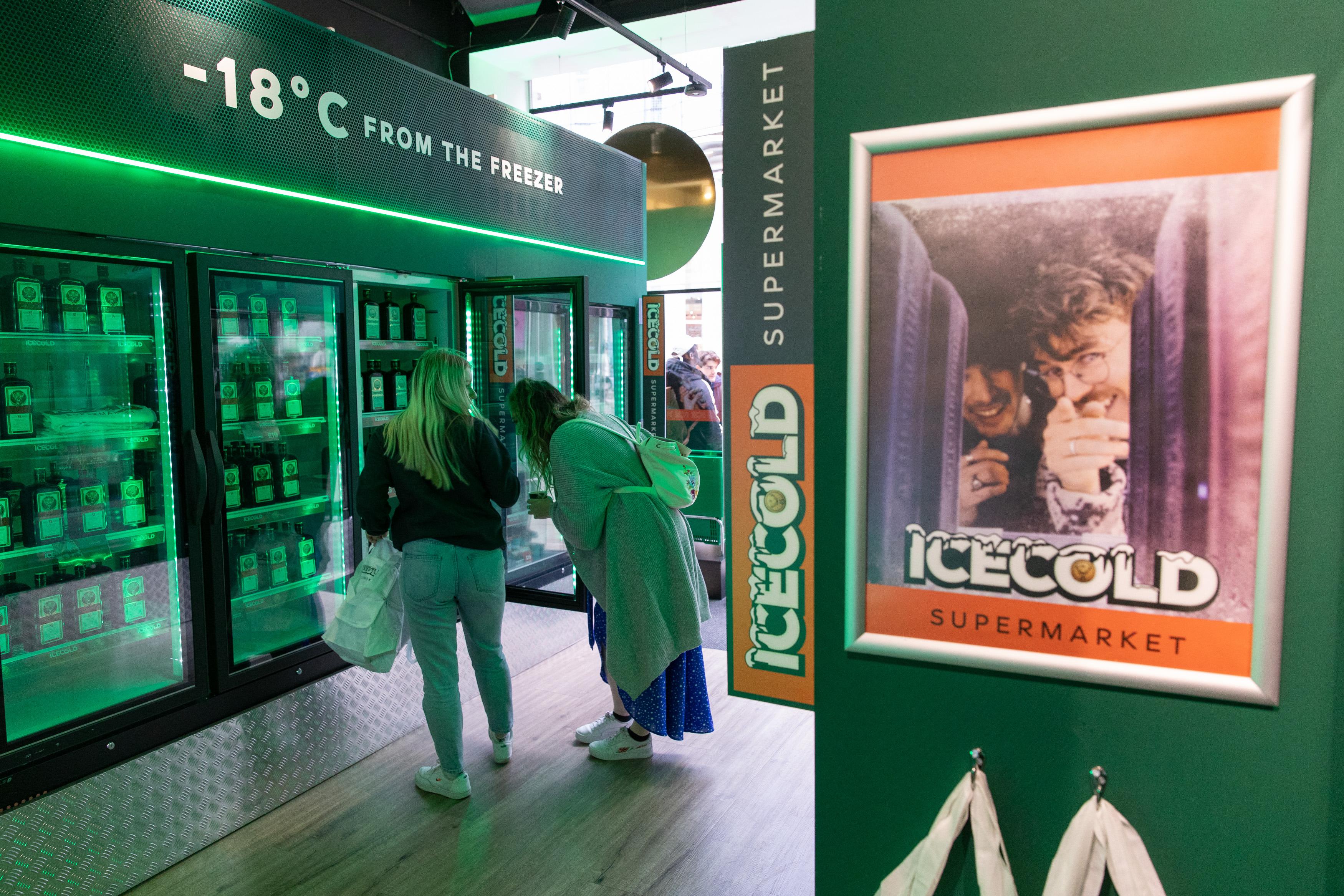 Shoppers looking in fridges at stock during Jagermeister pop up in Sook Oxford Street