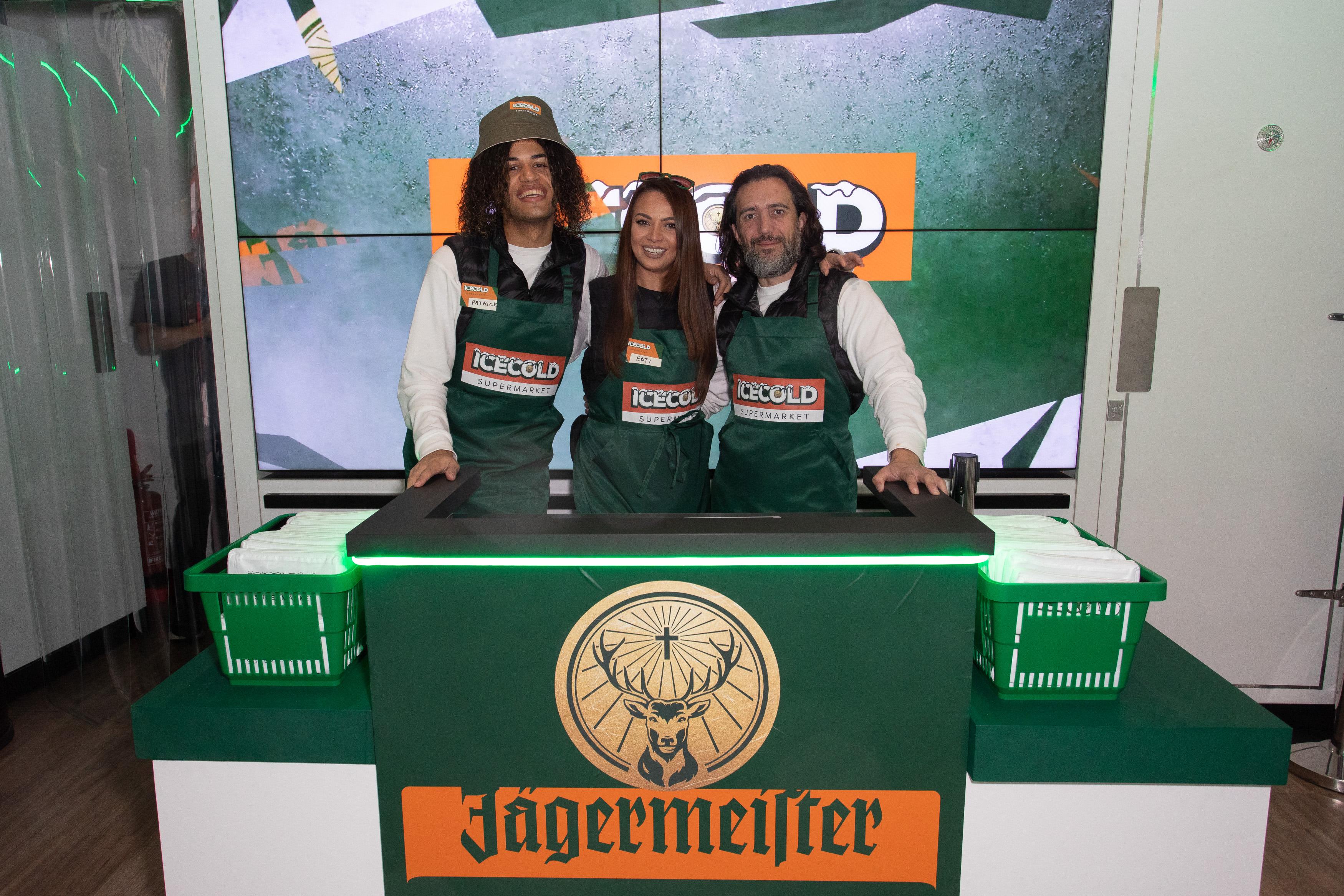 3 jagermeister staff behind cash desk smiling during Jagermeister pop up at Sook in Oxford Street