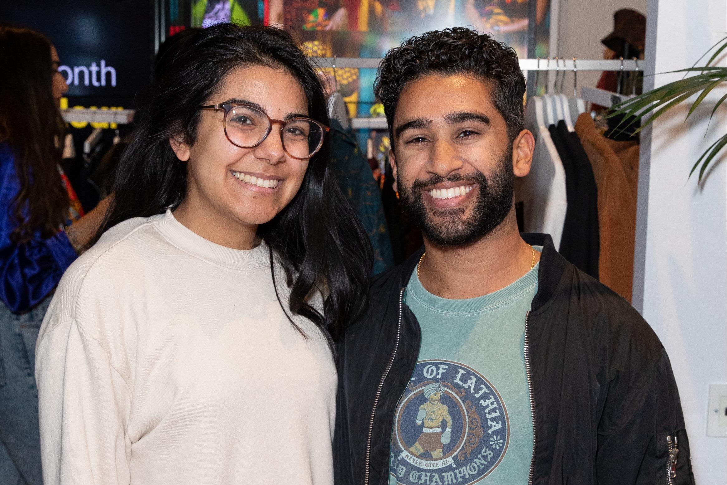 Woman and man smiling as they are at an opening party for a retail store